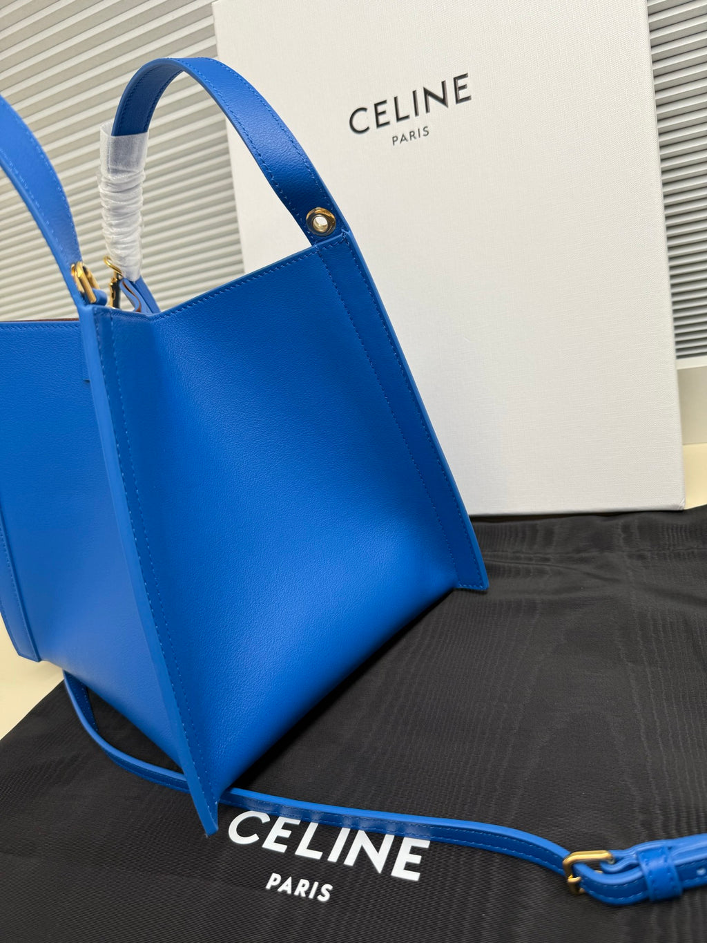 Celine blue leather tote bag at an angle with top handle and strap