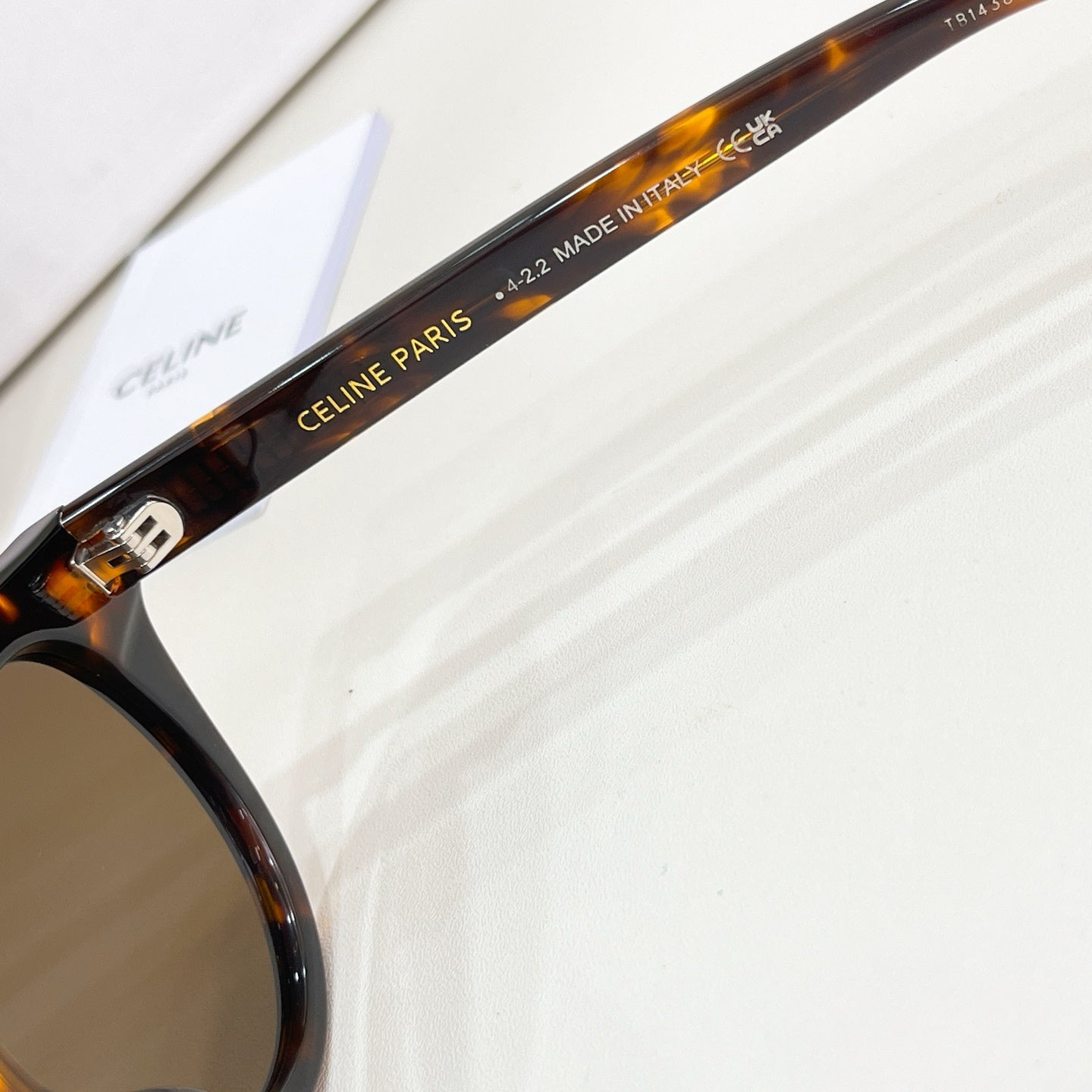 Black sunglasses temple with gold lettering and size markings