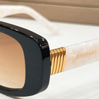 Bvlgari sunglasses detail: gold-tone temple logo on black frame