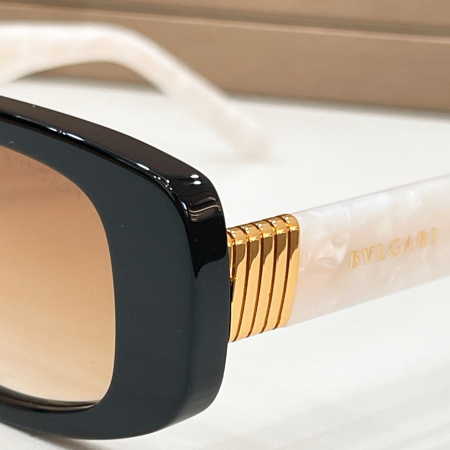 Bvlgari sunglasses detail: gold-tone temple logo on black frame