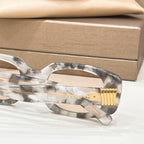 Bvlgari eyeglasses, close-up of clear gray frame with gold-tone temple hinge