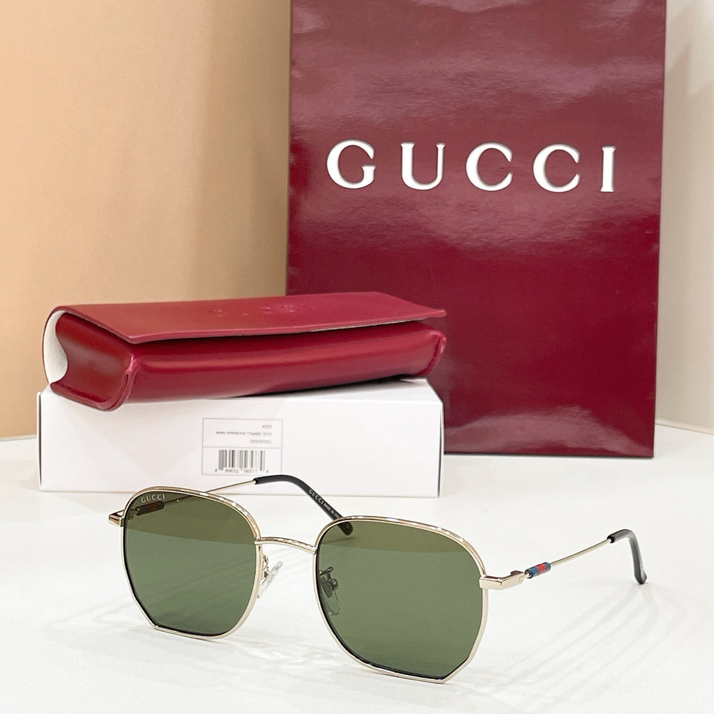 Sunglasses with gold octagonal frame and green tinted lenses