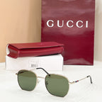Sunglasses with gold octagonal frame and green tinted lenses