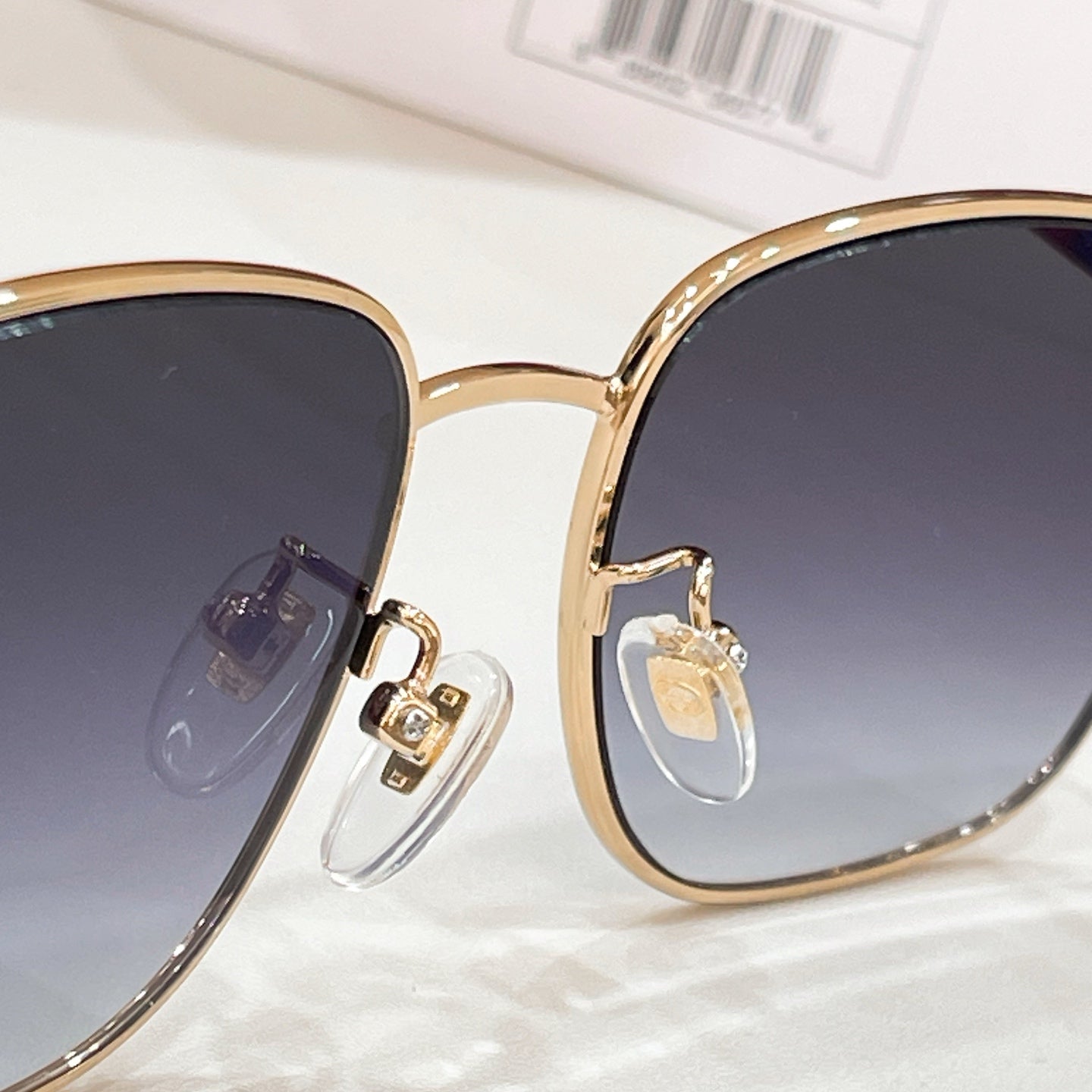 Close-up of gold-tone aviator sunglasses frame with dark lens and clear temple detail