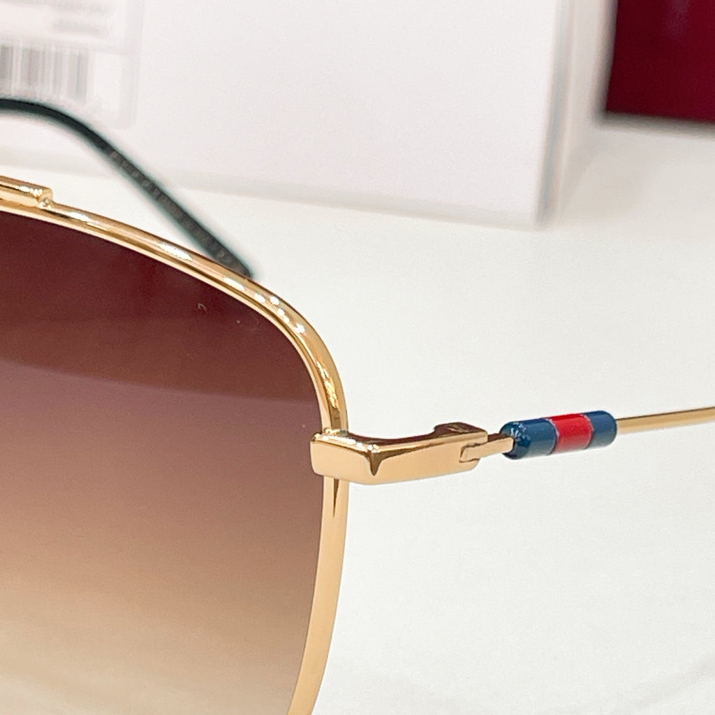 Gold eyeglass frame with temple hinge and blue/red enamel accent on the arm