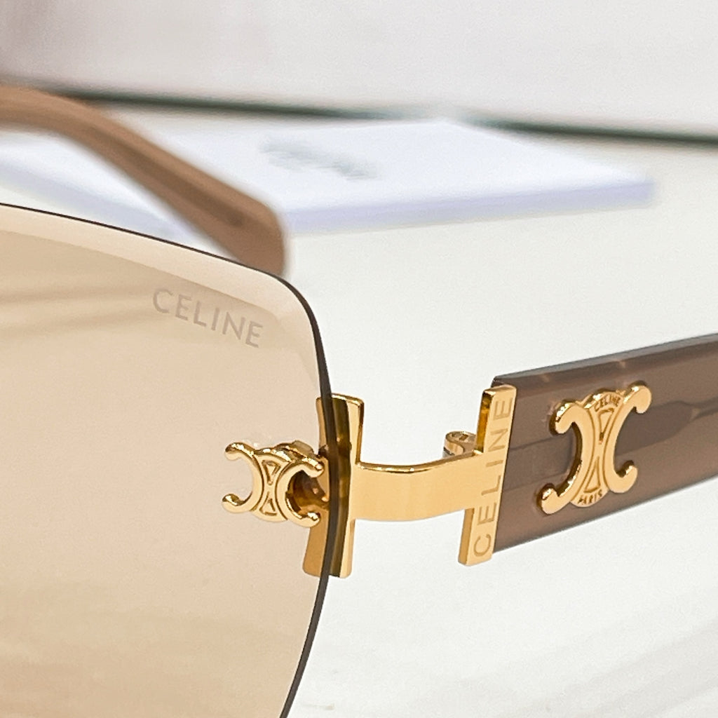 Celine sunglasses close-up of gold logo temple and dark tinted lens.