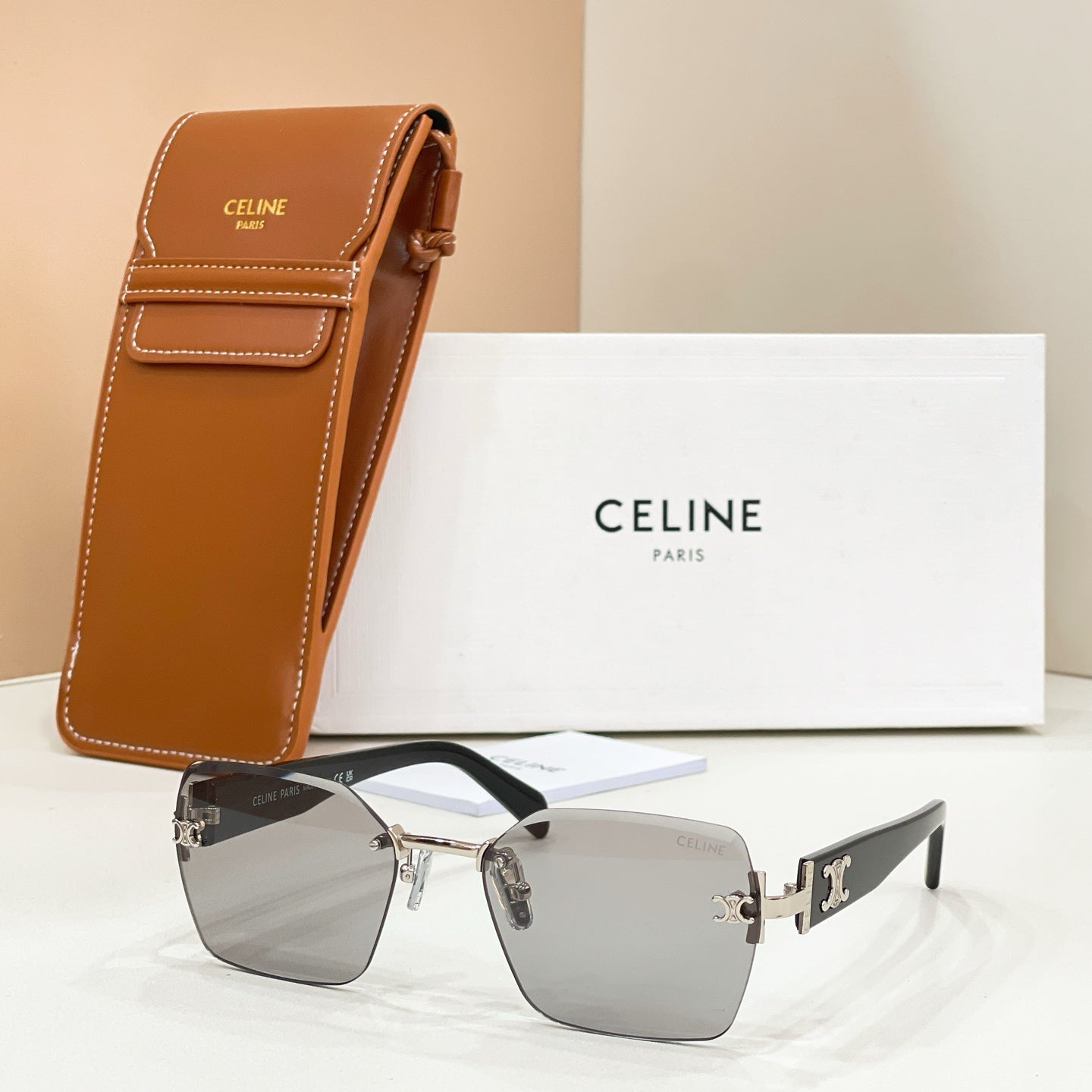 Celine sunglasses with silver frame, gray lenses, and brown leather case.
