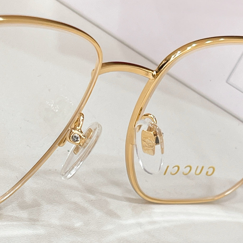 Gucci gold-rim eyeglasses with clear lenses, close-up front view