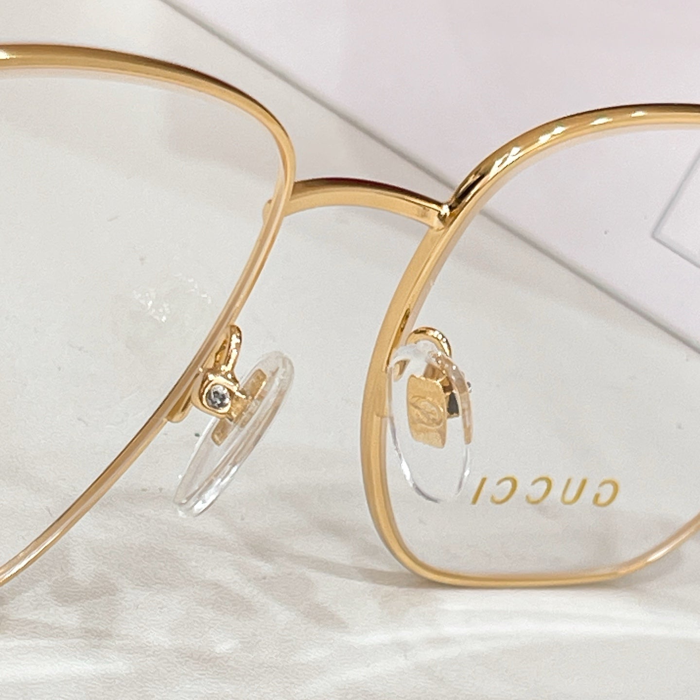 Gucci gold-rim eyeglasses with clear lenses, close-up front view