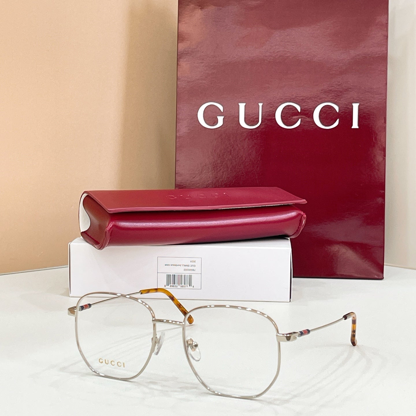 Gucci metal eyeglass frame with clear lenses, gold tone and tortoiseshell temple