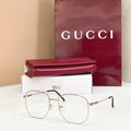 Gucci metal eyeglass frame with clear lenses, gold tone and dark temple tips