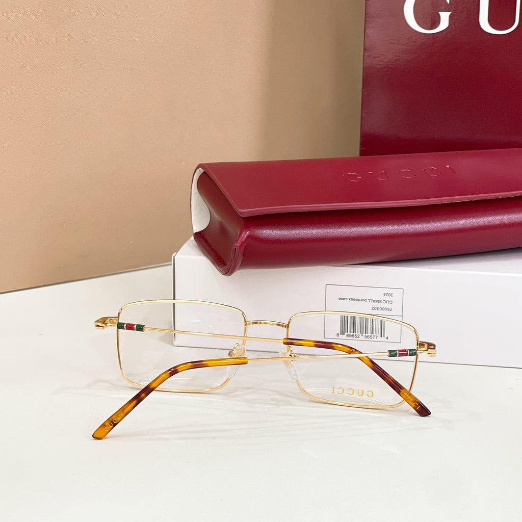 Gold eyeglasses with clear lenses and tortoise-pattern arms, side view