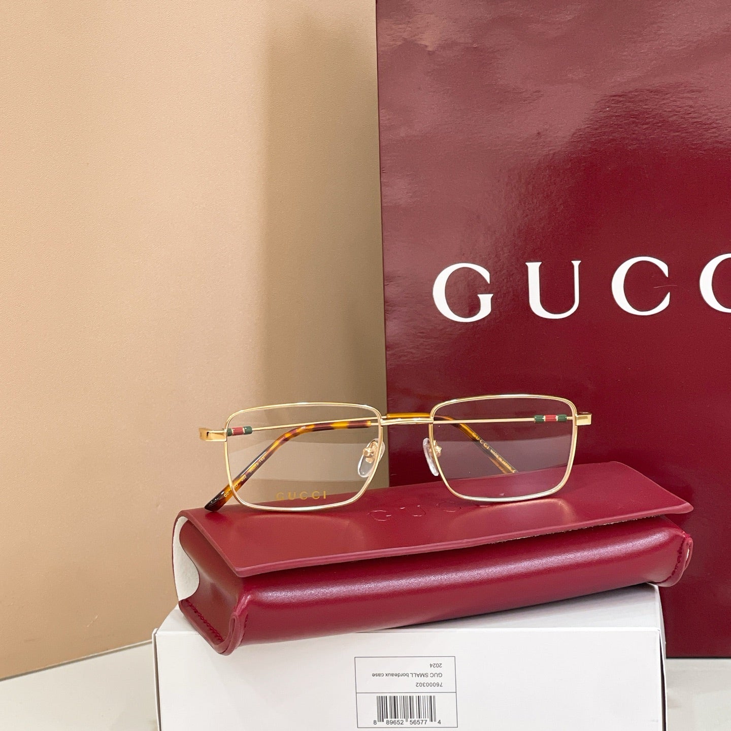 Gold rectangular eyeglasses with clear lenses and tortoise-pattern temples