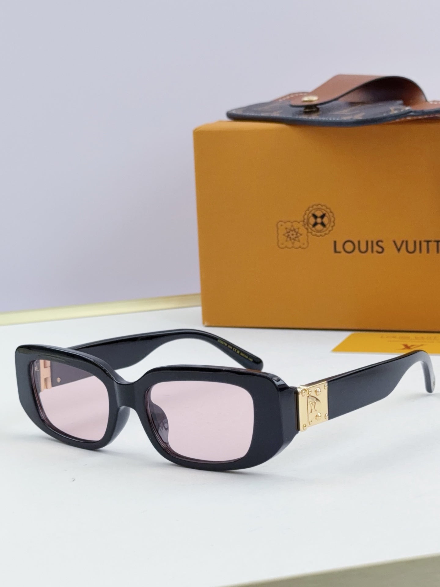 Louis Vuitton glasses, black frames with pale pink-tinted lenses and gold bridge detail
