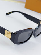 Louis Vuitton glasses, dark blue oval frames with tinted lenses and gold hinge detail