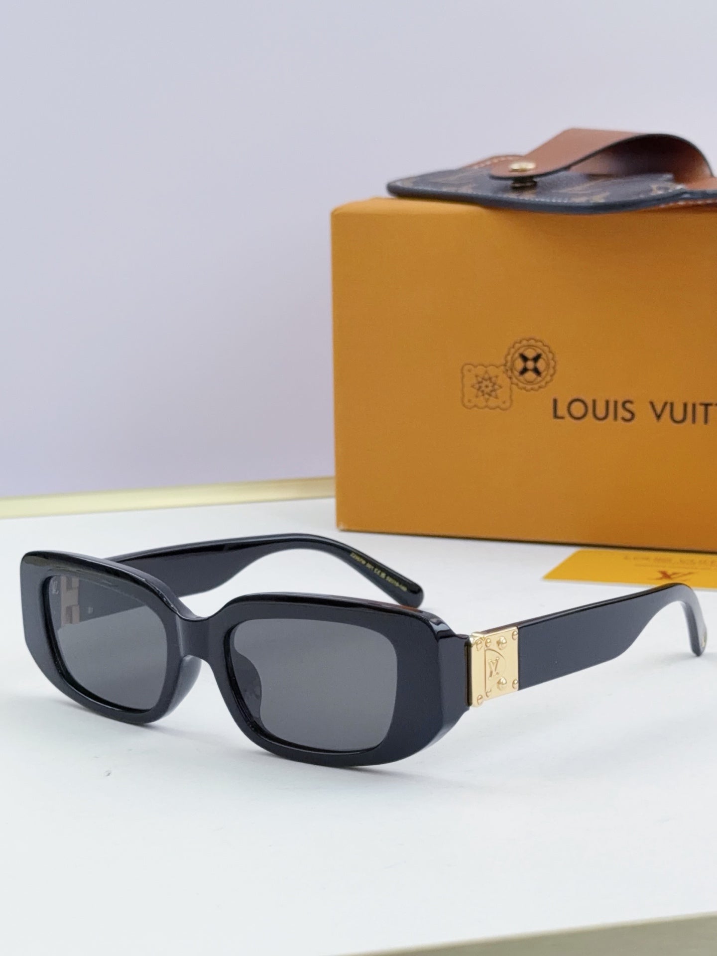Louis Vuitton glasses, black-and-white frames with dark lenses and gold bridge detail