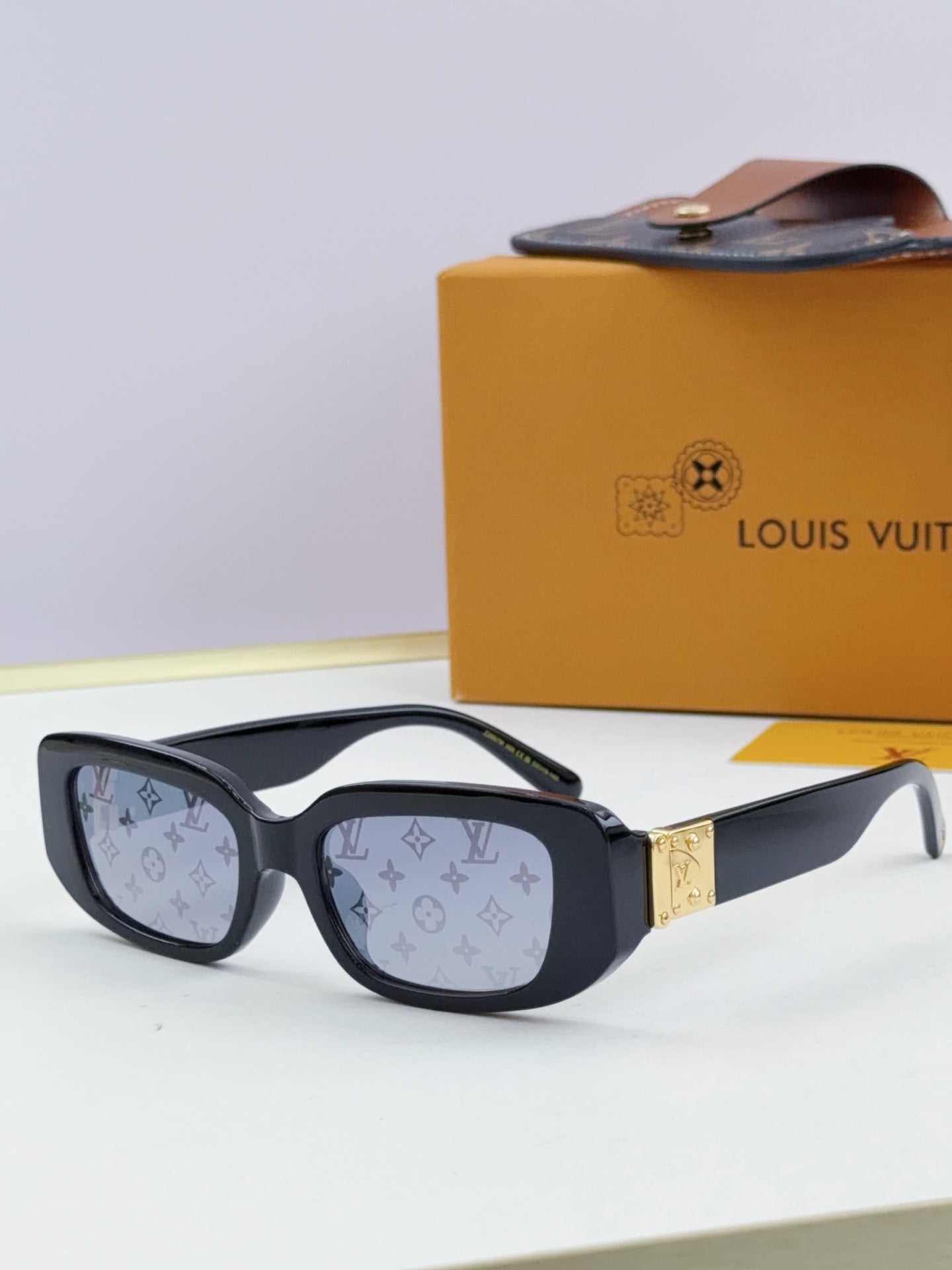 Louis Vuitton glasses, black frames with monogram-pattern lenses and gold bridge detail