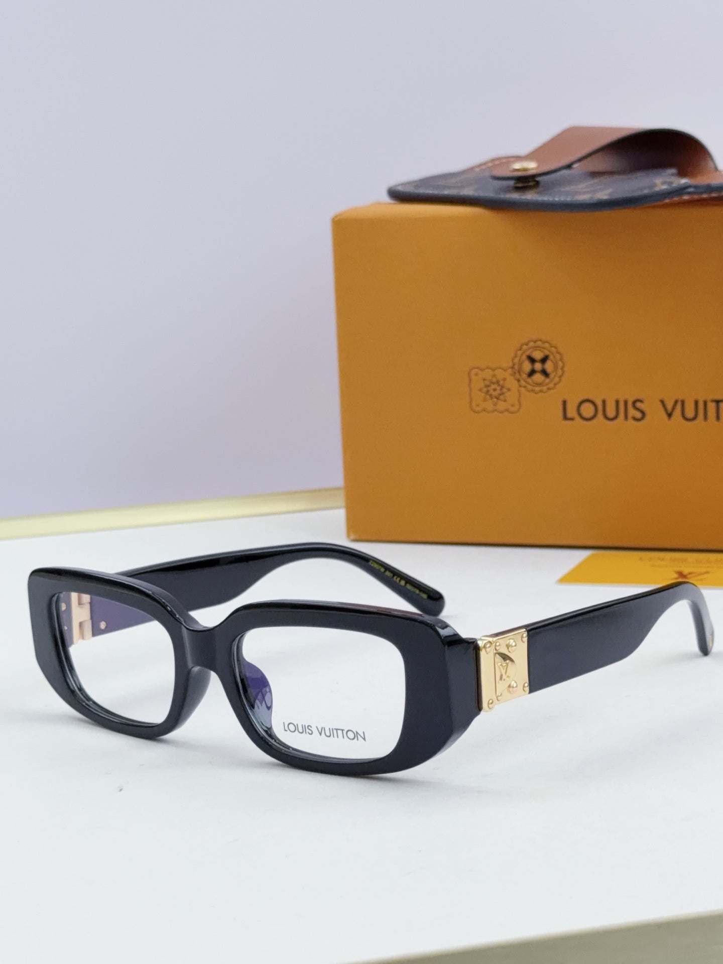 Louis Vuitton eyeglasses with black frames and gold logo detail at the hinge