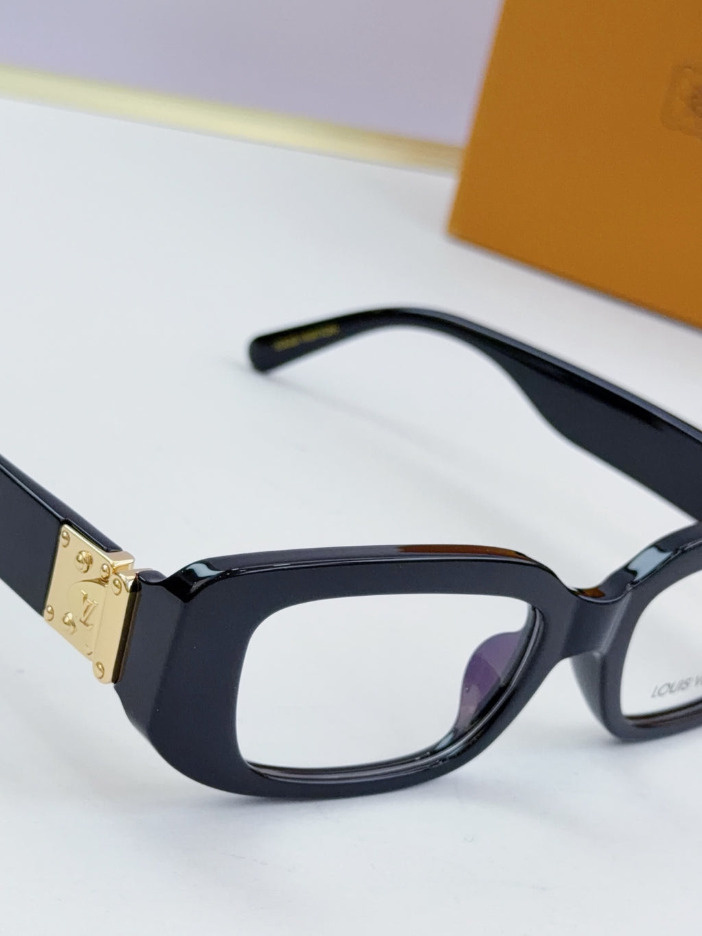 Louis Vuitton eyeglasses close-up: black frames with gold hinge hardware