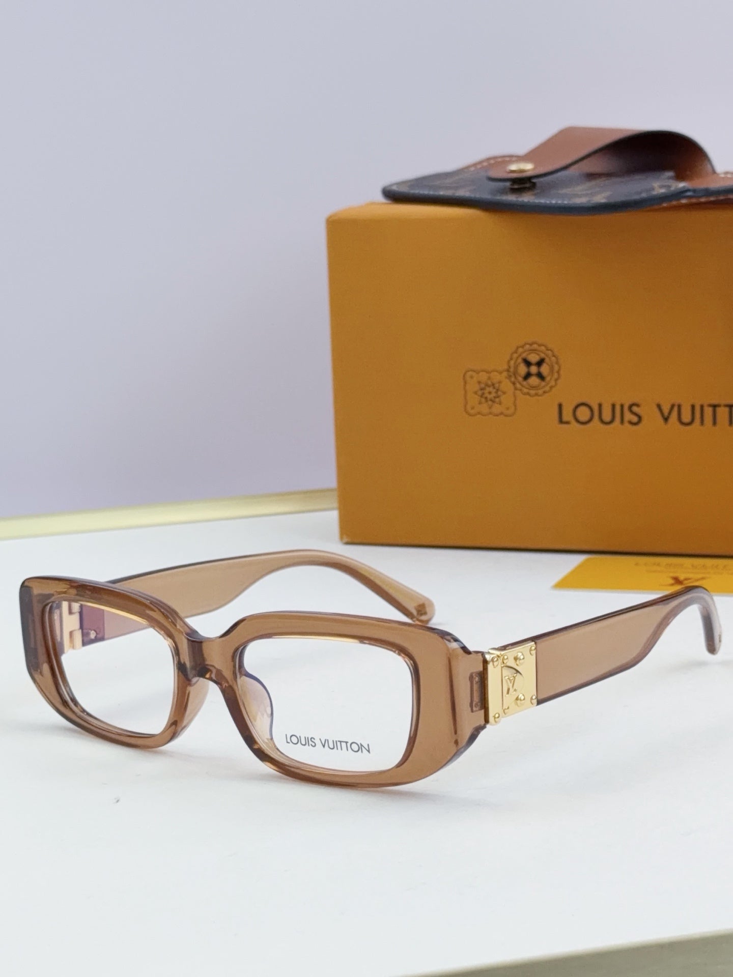 Louis Vuitton eyeglasses with light brown frames and gold logo detail