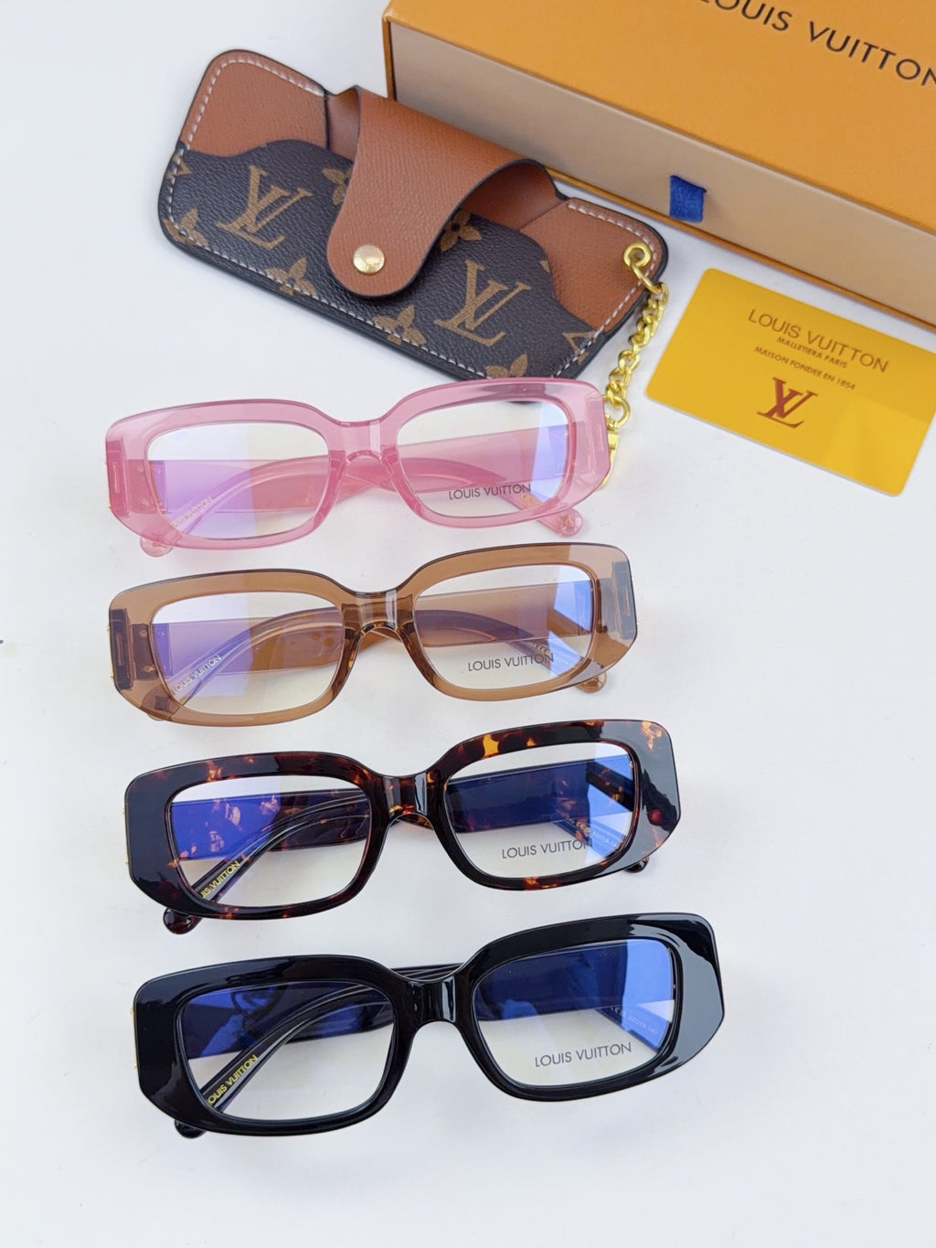 Assorted Louis Vuitton eyeglasses: pink, brown, dark tortoise, and navy frames with cases