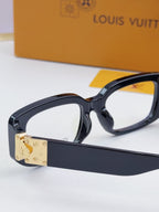 Louis Vuitton eyeglasses close-up: dark frames with gold front logo plate
