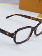 Louis Vuitton glasses close-up with tortoiseshell frames and gold side logo