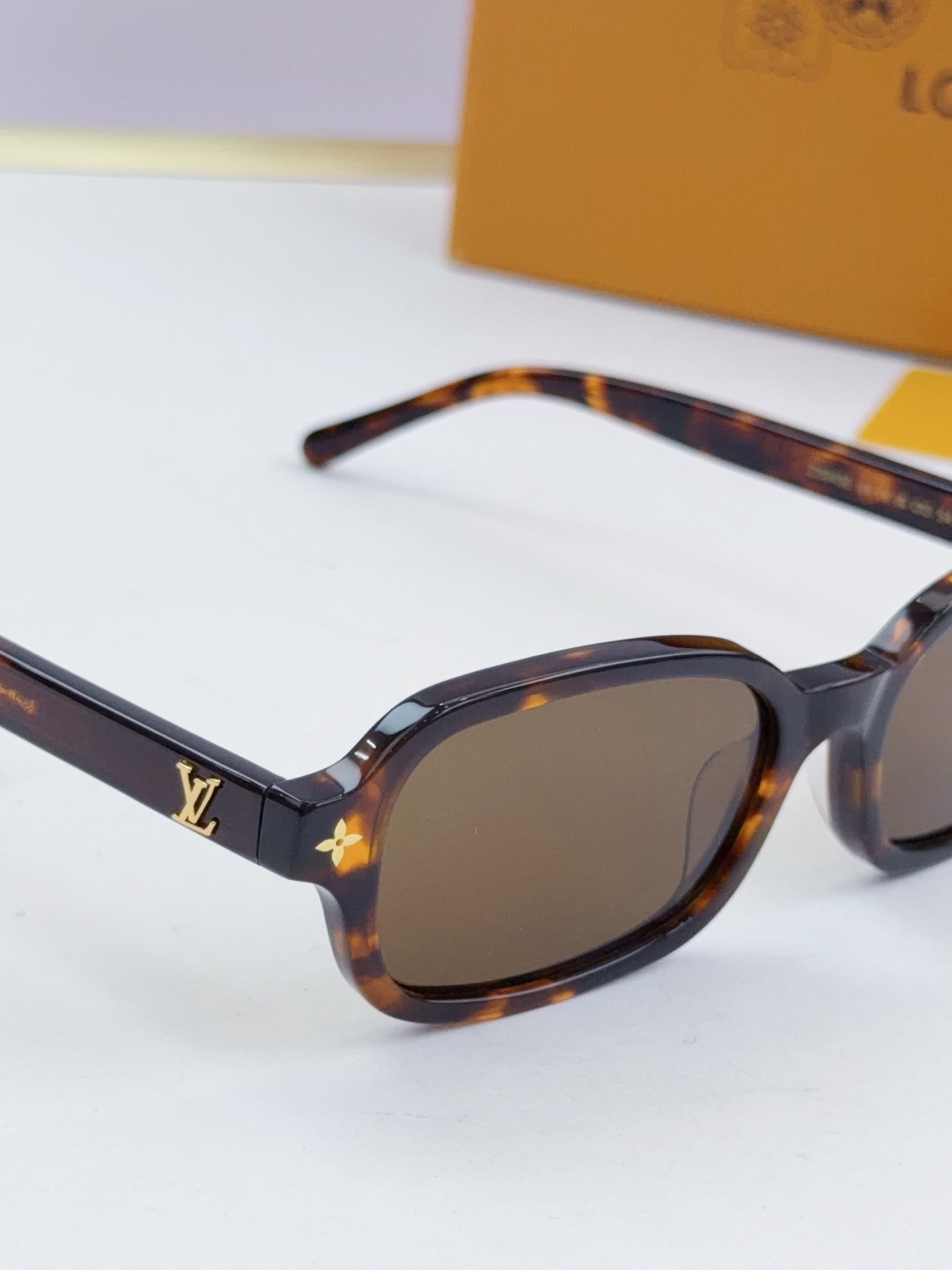 Louis Vuitton sunglasses with tortoiseshell oval frames and dark lenses