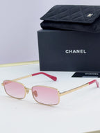 Gold Chanel glasses with pink-tinted lenses and red temple detail