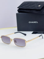 Gold Chanel glasses with rose-tinted lenses and black temple tips