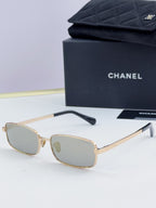 Gold Chanel glasses with pale lenses and subtle patterned temple accents