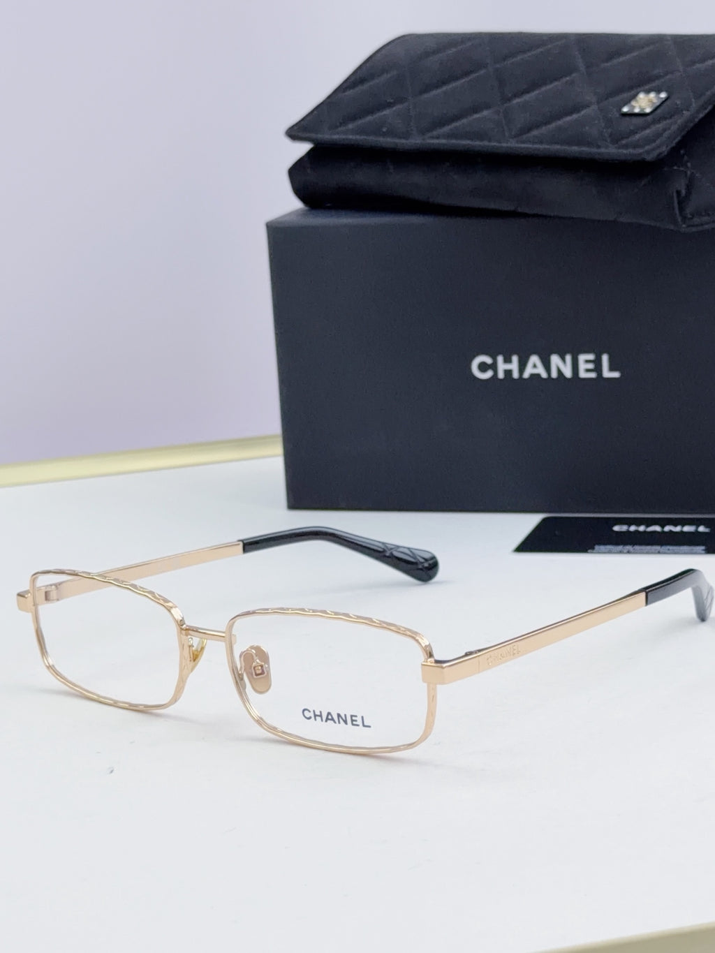 Gold Chanel glasses with light lenses and dark temple tips