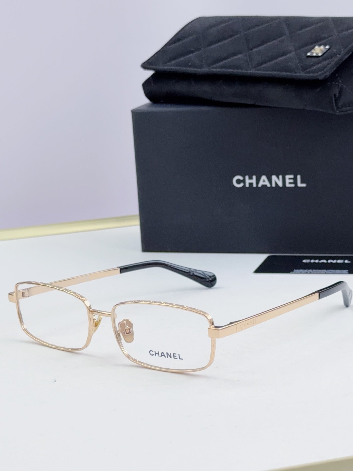Gold Chanel glasses with light lenses and dark temple tips