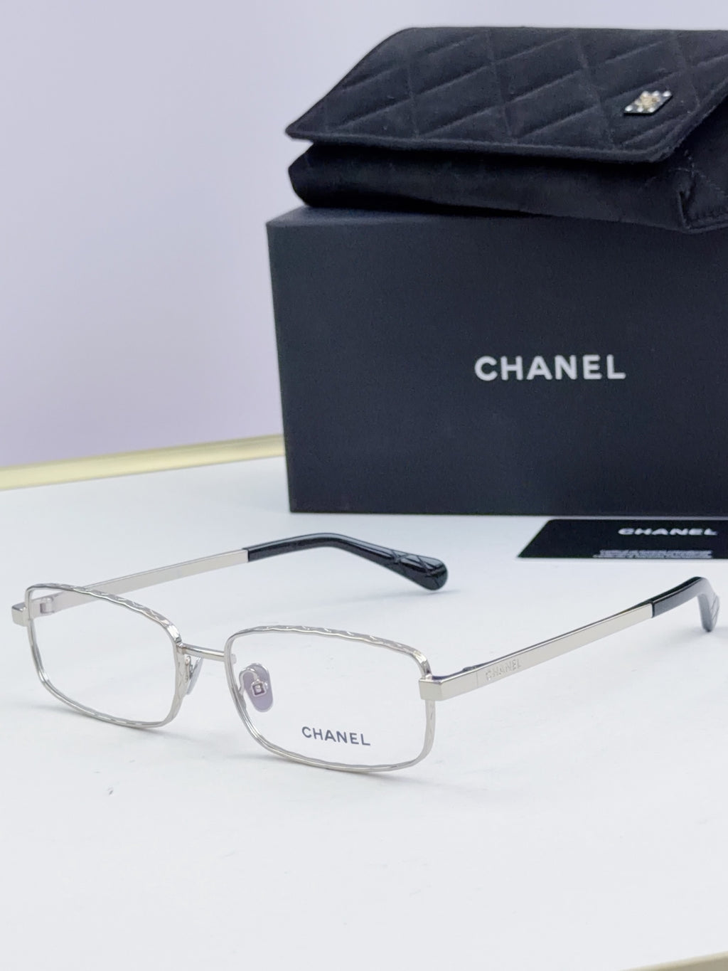 Clear Chanel glasses with light gray lenses and thin metal temple arms