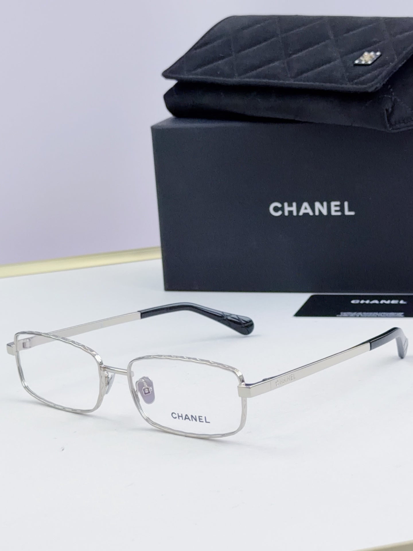 Clear Chanel glasses with light gray lenses and thin metal temple arms