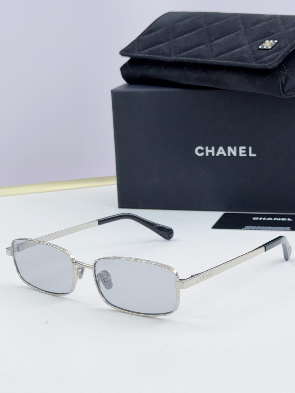 Silver Chanel glasses with light gray lenses and slender metal temples