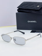 Silver Chanel glasses with light gray lenses and slender metal temples