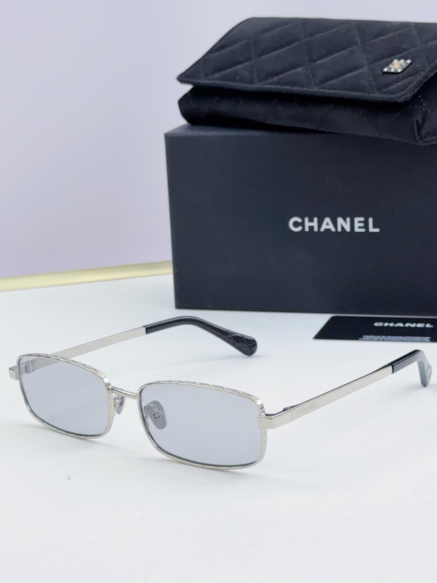 Silver Chanel glasses with light gray lenses and slender metal temples