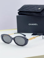 Chanel round sunglasses with dark lenses and black frames, gold chain detail on temples.