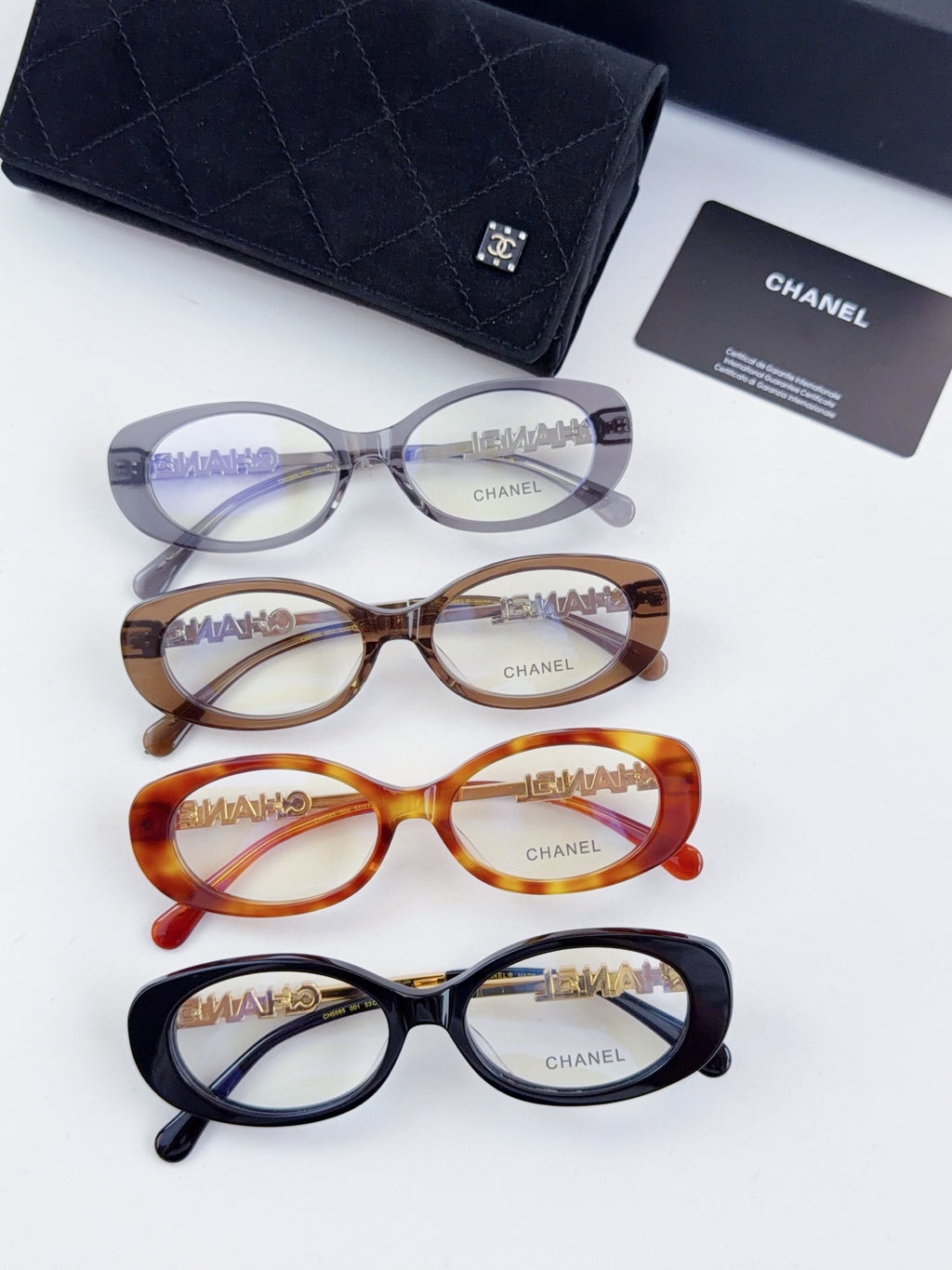 Chanel eyeglasses set with three round frames and matching dark case; clear lenses shown.