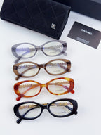 Chanel eyeglasses set with three round frames and matching dark case; clear lenses shown.