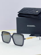 Chanel square sunglasses with dark frame, gold-tone logo arms, yellow-tinted lenses