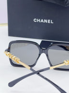 Chanel square sunglasses with dark frame, gold-tone logo arms, tinted gray-blue lenses