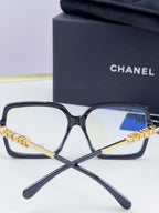 Chanel eyeglass frames, black square acetate with gold logo arms and blue-tinted lenses
