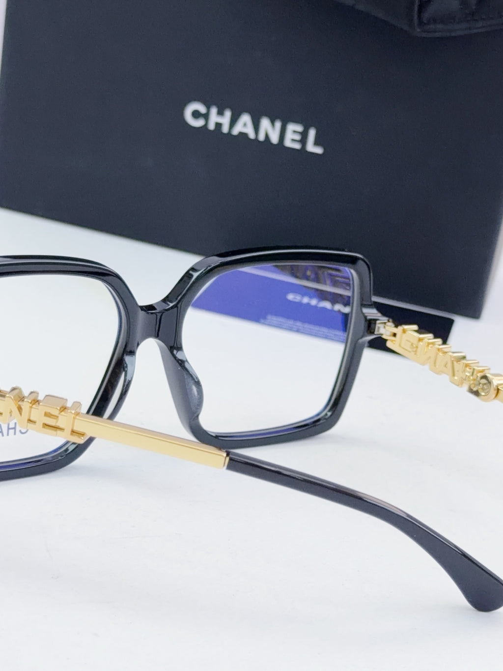 Chanel eyeglass frames, dark gray square acetate with blue lens tint and gold logo detail