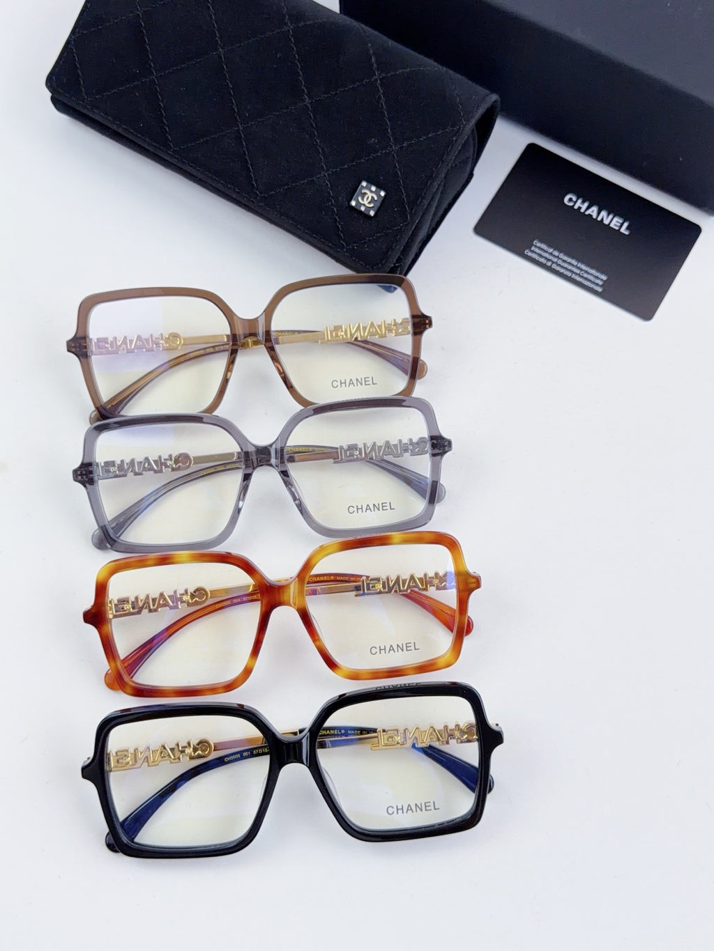 Three pairs of Chanel eyeglass frames: brown, blue, and orange square styles on display