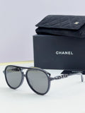 Chanel round sunglasses with dark frames and gray lenses, front view.