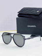 Chanel round sunglasses with dark frames and gray lenses, front view.