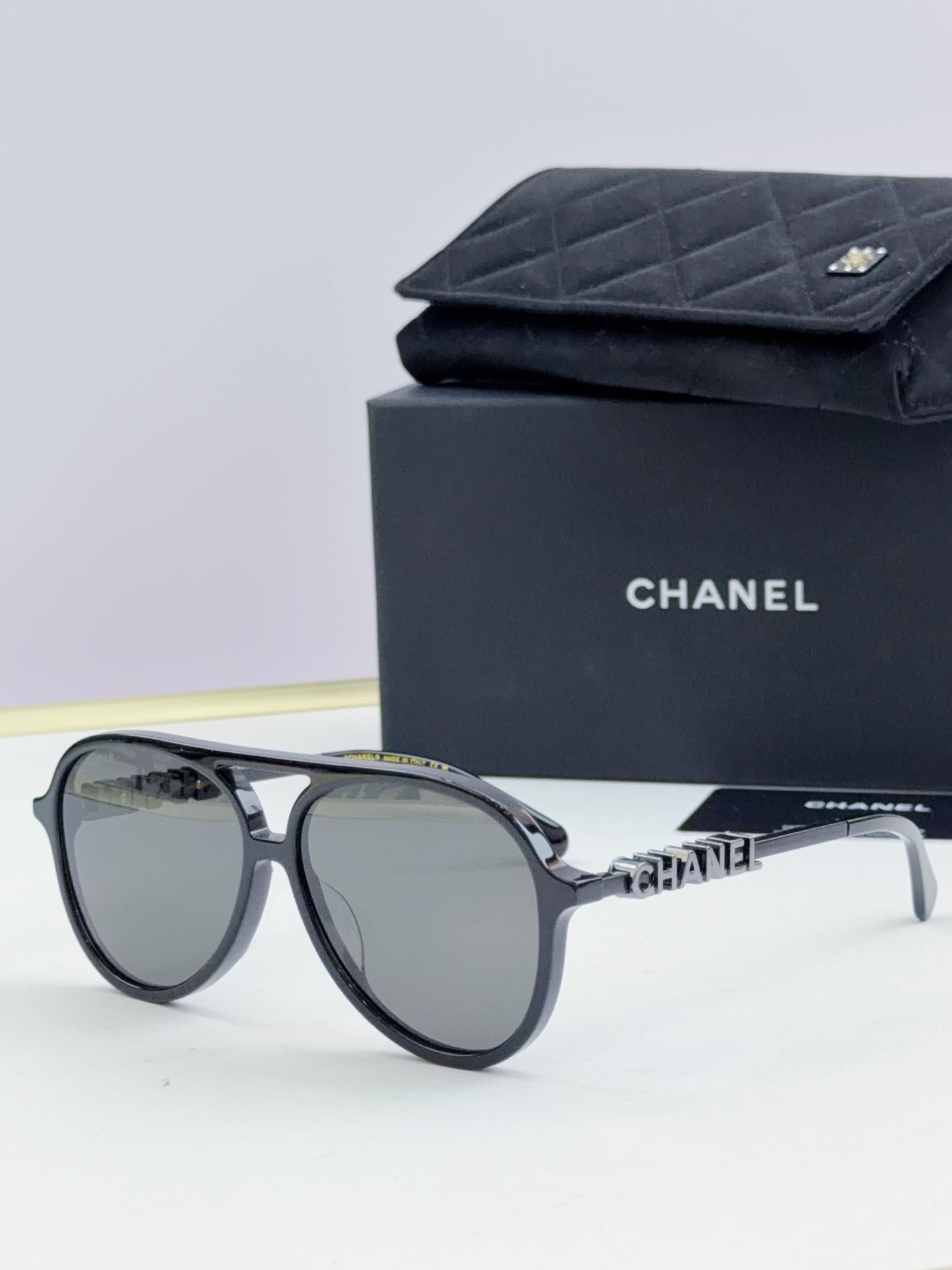 Chanel round sunglasses with dark frames and gray lenses, front view.