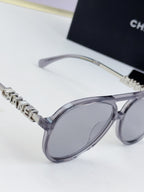 Chanel round sunglasses close-up: silver frame and branded temple detail.